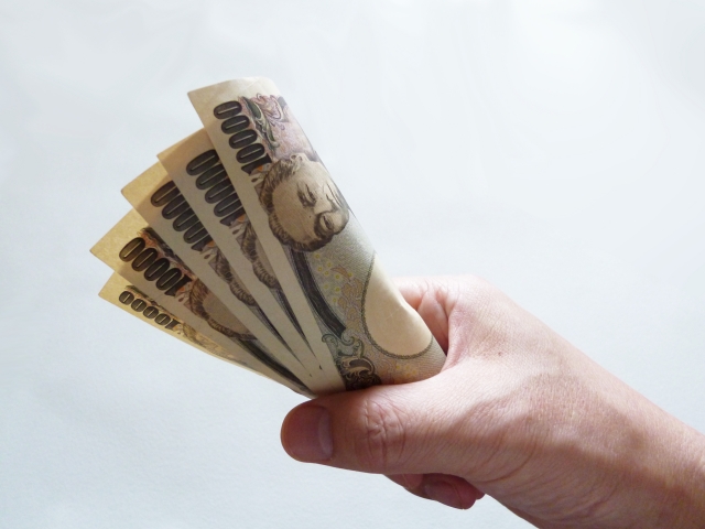 お金を握りしめる手